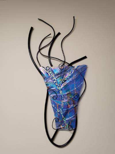 Blue Caldron: blue and purple iridescent fused glass with feathery patterns, framed in a black wrought-iron cauldron-shape.