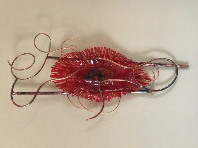 Feminine Mystique: a red fused-glass starburst flower on a copper armature with curling tendrils.