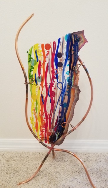 Rainbow Caldron: a rainbow-striped fused-glass panel held in a copper cauldron-shaped armature with curling legs.