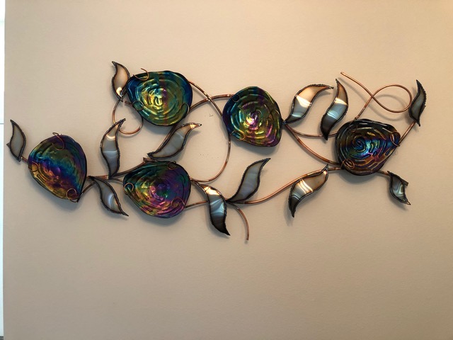 Rolling Florals: a long horizontal piece of iridescent fused-glass roses and leaves arranged across a copper vine.