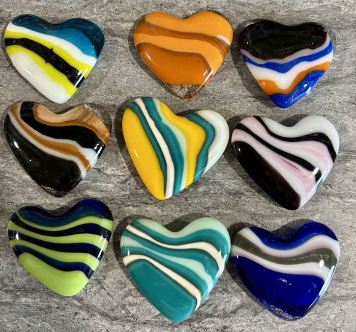 Striped Hearts free tutorial cover: nine fused-glass hearts in orange, black, turquoise, blue and white, each with wavy stripes running through it.