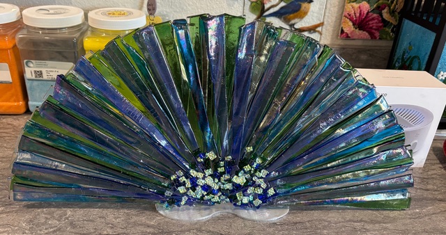 Fans: a fused-glass fan-shaped piece in deep blue with white accents, on its own attached stand.